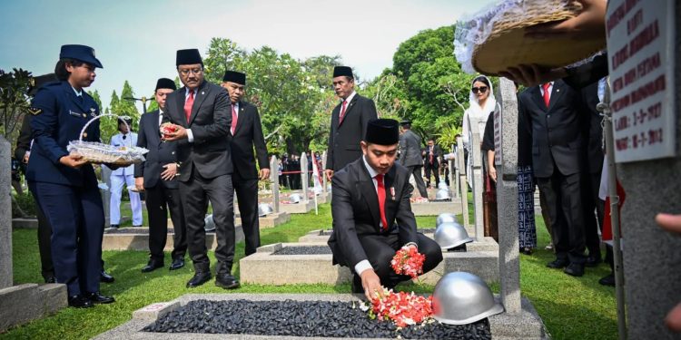 Wakil Presiden Gibran Rakabuming Raka sedang menabur bunga di salah satu makan pahlawan. Foto: Setwapres