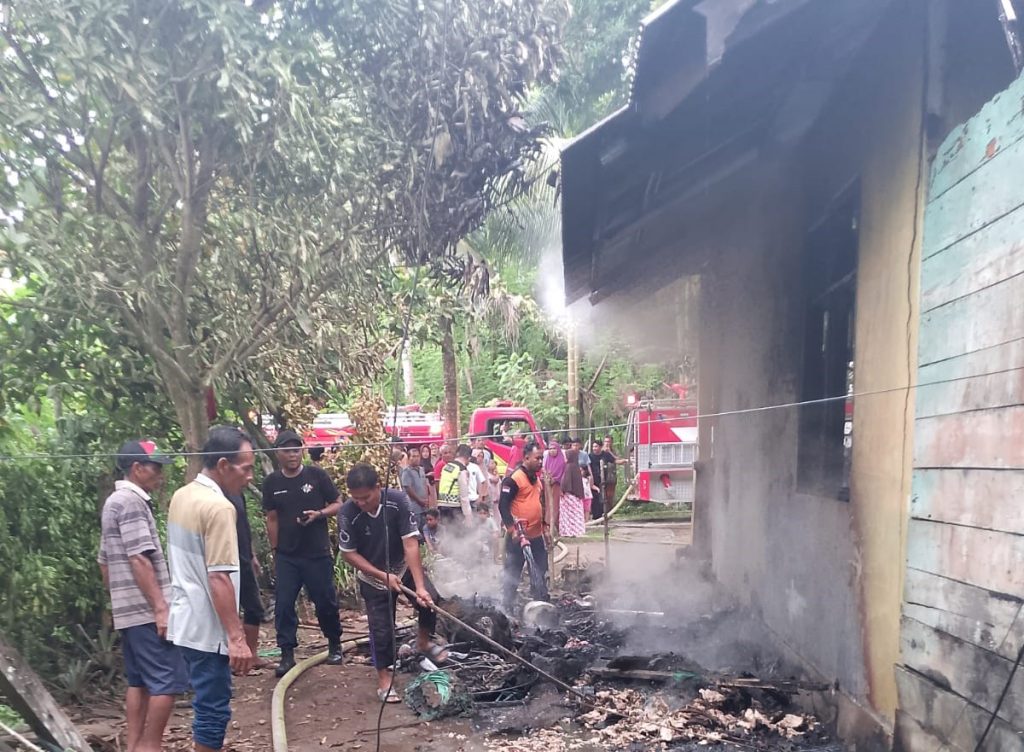 Saat para petugas dan warga memadamkan sisa-sisa api di rumah warga yang terbakar